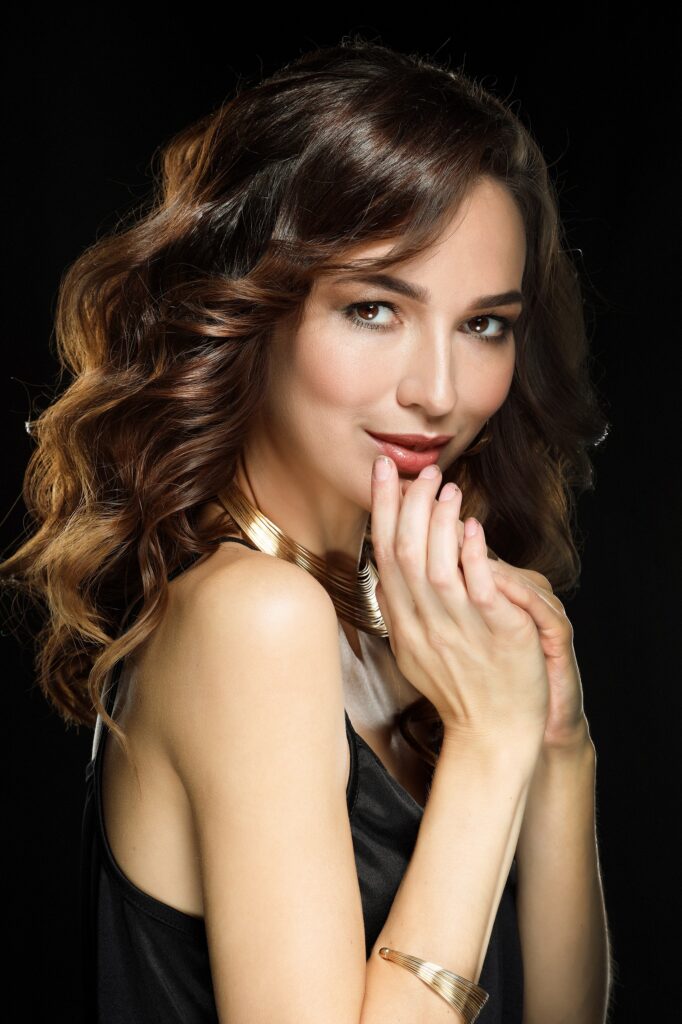 Young beautiful woman with long and shiny curly hair. Beautiful model woman with curly hairstyle. Beauty concept.