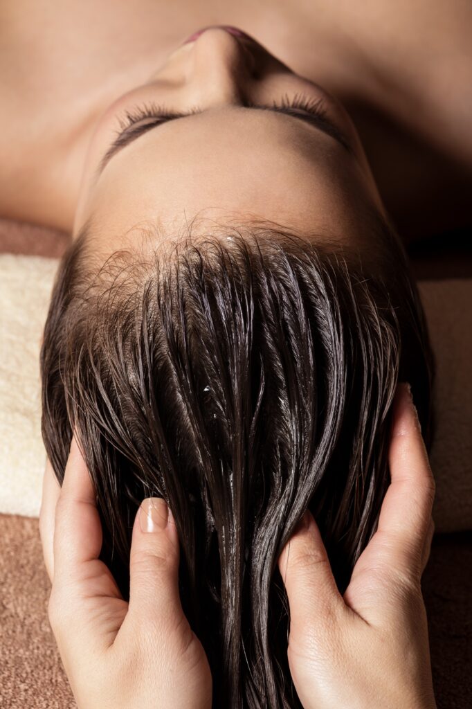 Cosmetologist massaging hair on the head of the woman. Spa treatments. Beauty treatment. Spa salon
